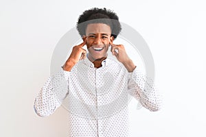 Young african american man wearing elegant shirt standing over isolated white background covering ears with fingers with annoyed