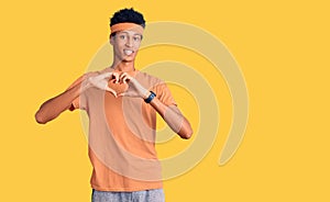 Young african american man wearing sportswear smiling in love showing heart symbol and shape with hands