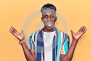 Young african american man wearing summer clothes and sunglasses celebrating victory with happy smile and winner expression with