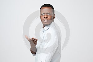 Young african american man in white shirt dissatisfied frowns and looks sullenly. photo
