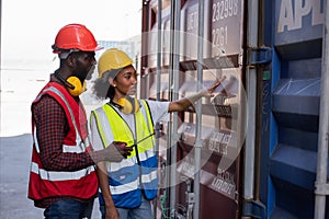 Young African american man and woman worker check and control loading freight containers