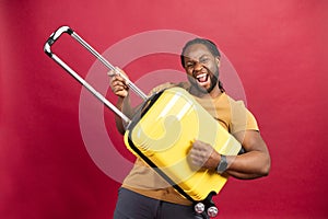 Young African American man with yellow suitcase