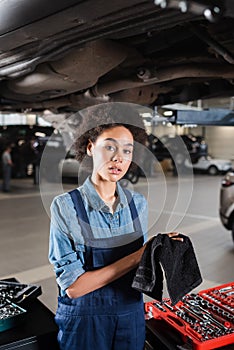 young african american mechanic standing underneath