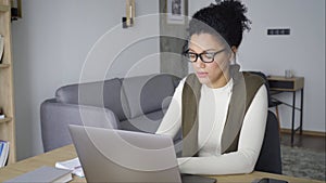 Young African American mixed race girl sitting at desk typing on pc indoors.