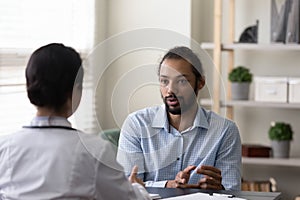 Young african american patient discussing illness treatment with doctor.