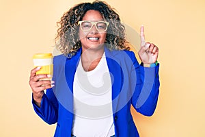 Young african american plus size woman wearing glasses holding take away cup of coffee smiling with an idea or question pointing