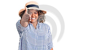 Young african american plus size woman wearing summer hat smiling friendly offering handshake as greeting and welcoming