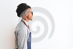 Young african american shopkeeper man wearing apron glasses over isolated white background looking to side, relax profile pose