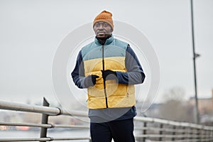 Young African American sportsman in activewear jogging outdoors in the morning