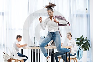 young african american student girl jumping in classroom