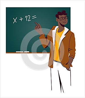 A young African-American teacher with glasses and a brown jacket stands at the blackboard with an example and explains