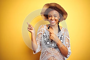 Young african american woman with afro hair wearing summer hat over white isolated background smiling and looking at the camera