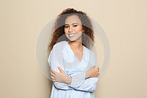 Young African-American woman with beautiful face on beige