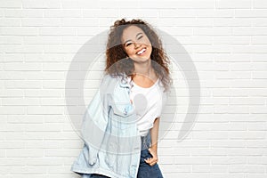 Young African-American woman with beautiful face near white brick