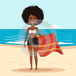 Young African American woman in bikini holding towel on beach. Smiling black female standing by the sea, summer vacation