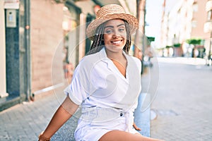 Young african american woman with braids smiling happy outdoors on a sunny day of summer