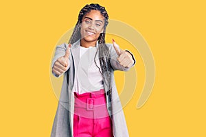 Young african american woman with braids wearing business clothes approving doing positive gesture with hand, thumbs up smiling