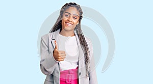 Young african american woman with braids wearing business clothes doing happy thumbs up gesture with hand