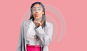 Young african american woman with braids wearing business clothes looking at the camera blowing a kiss with hand on air being