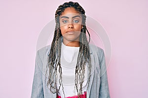 Young african american woman with braids wearing business jacket with serious expression on face