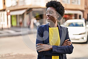 Young african american woman business executive standing with arms crossed gesture at street