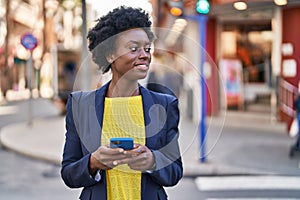 Young african american woman business executive using smartphone at street