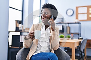 Young african american woman business worker talking on the smartphone drinking coffee at office