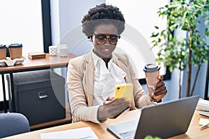 Young african american woman business worker using smartphone drinking coffee at office