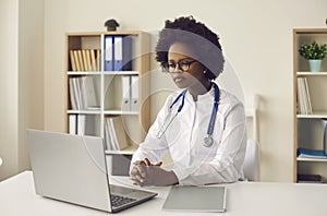 Young african american woman doctor giving online consultation via laptop