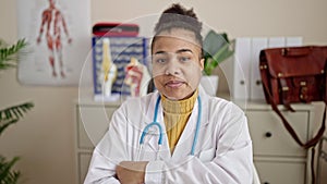 Young african american woman doctor using laptop smiling at clinic