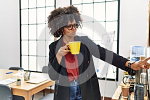 Young african american woman drinking coffee at office