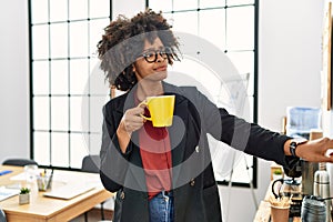 Young african american woman drinking coffee at office
