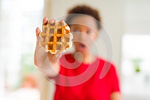 Young african american woman eating sweet waffle scared in shock with a surprise face, afraid and excited with fear expression