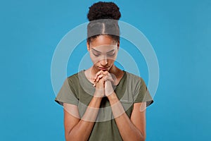 Young african american woman girl in casual t-shirt posing isolated on bright blue background studio portrait. People