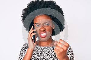 Young african american woman having conversation talking on the smartphone annoyed and frustrated shouting with anger, yelling
