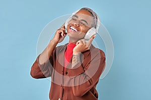 Young African American woman in headphones experiences euphoria from music