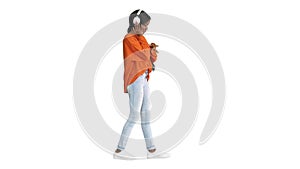Young african american woman with headphones listening and grooving to music on white background.