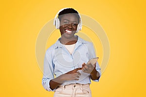 Young african american woman with headphones and phone