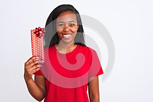 Young african american woman holding birthday present over isolated background with a happy face standing and smiling with a