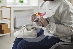 Young African American woman holding an orthotic arch support insole for her shoes