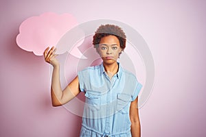 Young african american woman holding speech bubble over pink isolated background with a confident expression on smart face