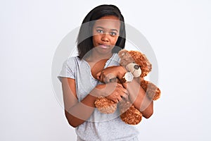 Young african american woman holding teddy bear over isolated background with a confident expression on smart face thinking