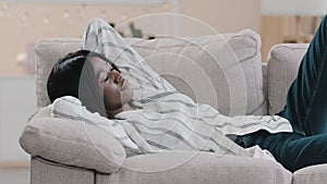 Young african american woman lies relaxing on comfortable couch with closed eyes attractive girl resting moving to your