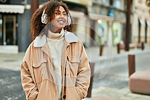 Young african american woman listening to music at the city