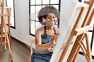 Young african american woman listening to music drawing at art studio
