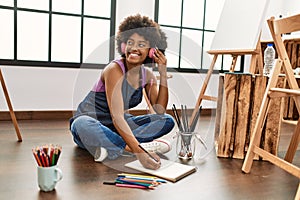 Young african american woman listening to music drawing at art studio