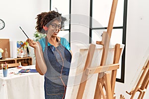 Young african american woman listening to music drawing at art studio