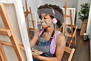 Young african american woman listening to music drawing at art studio