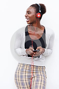 Young african american woman listening to music with mobile phone and headphones