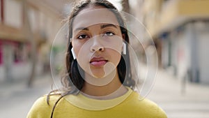 Young african american woman listening to music at street